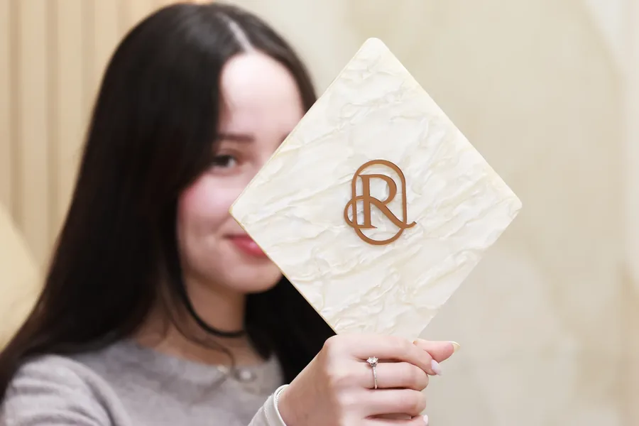 Patient holding a Restore Dental Aesthetics monogram sign