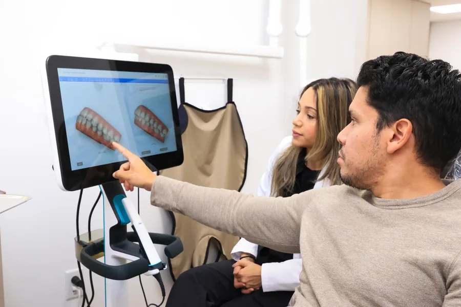 Patient pointing at the digital simulation of their aligned smile