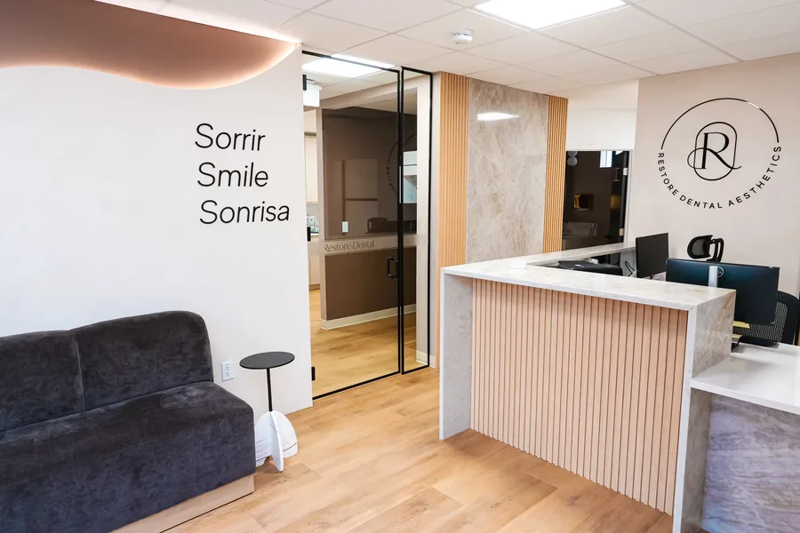 Reception desk beside the Sorrir Smile Sonrisa wall at the Peabody dental office