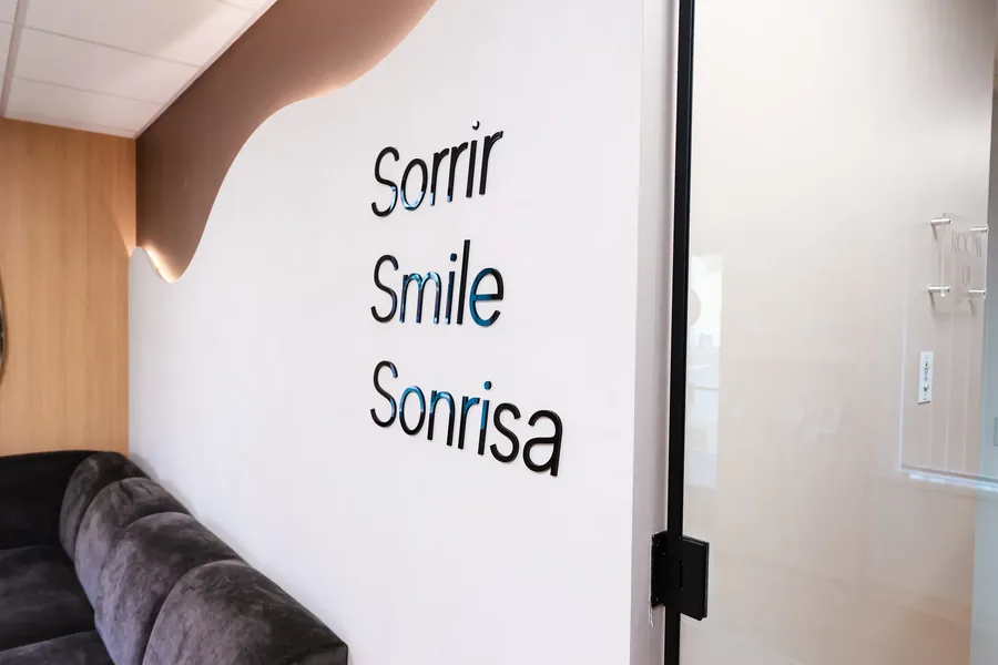 Wall lettering reading Sorrir, Smile, Sonrisa in the waiting room