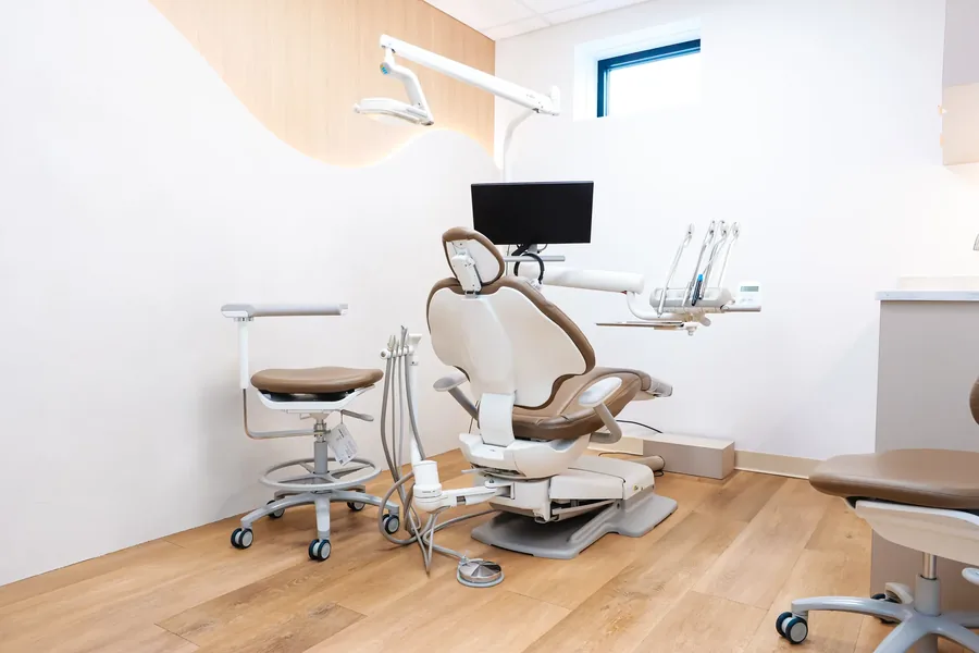 Treatment room with dental chair, operating light and monitor at the Peabody office
